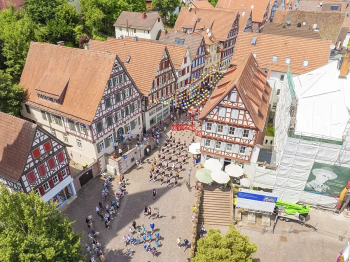 Framed Print : Aerial view of a town square surrounded by half-timbered houses with many people at a celebration