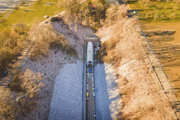 Framed Print : Aerial view of a train line through an autumnal forest and open meadows