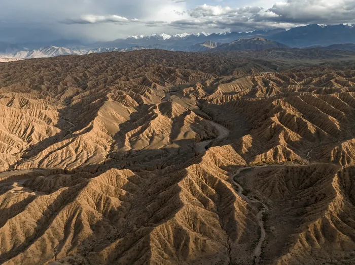 Framed Print : Aerial view, view over eroded hills towards mountains of the Tian Shan Framed Print : Aerial view, view over eroded hills towards mountains of the Tian Shan