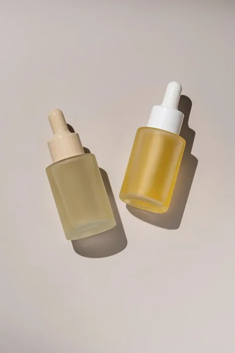 Framed Print : Aesthetic presentation of two skincare serum bottles with droppers casting subtle shadows on a neutral background Ideal