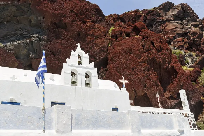 Framed Print : Agios Nikolaos Mavrorachidi, chapel with bell tower and Greek flag in front of red rock face