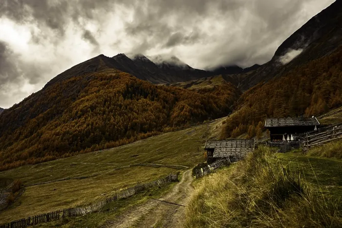 Framed Print : Alpine hut in autumnal mountain landscape with threatening cloudy sky