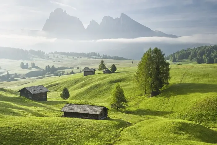 Framed Print : Alpine huts on green pastures in front of mountains
