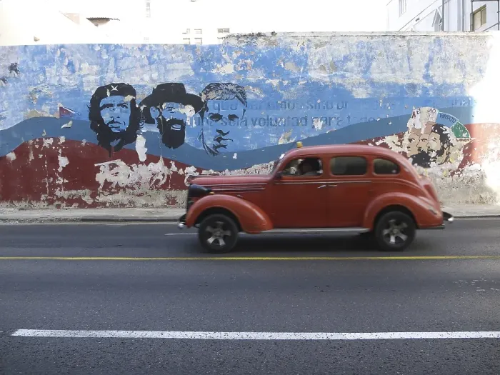 Framed Print : American vintage car driving along a wall with paintings of Fidel Castro and Che Guevara