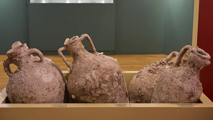 Framed Print : Three ancient amphorae with earth remains on display in a museum