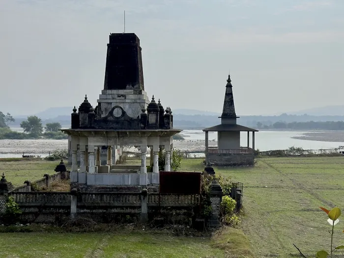 Framed Print : An ancient temple by a river in a rural landscape with a cloudy sky in the background