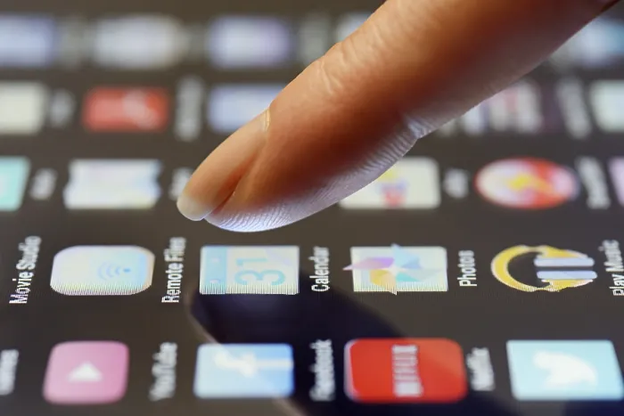 Framed Print : App being selected by a finger on a touchscreen