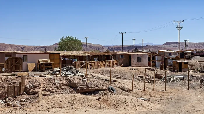 Framed Print : An arid landscape with simple buildings and electricity pylons under a clear sky
