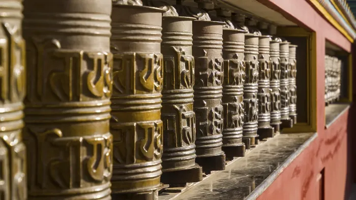 Framed Print : Artfully decorated metal prayer wheels in a row in a monastic setting with intensive play of light and shadow