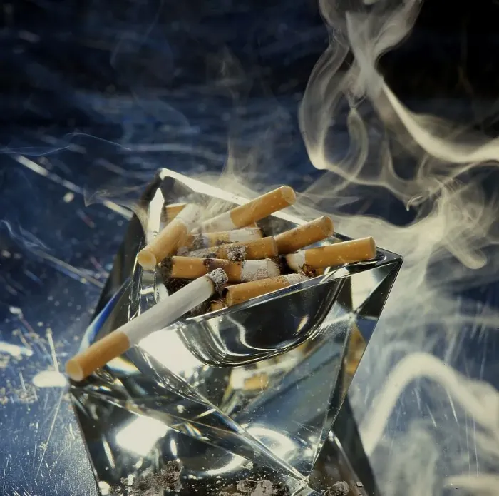 Framed Print : Ashtray with smoking cigarette butts