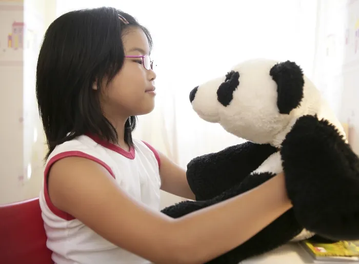 Framed Print : Asian girl looking at her panda teddy bear Framed Print : Asian girl looking at her panda teddy bear