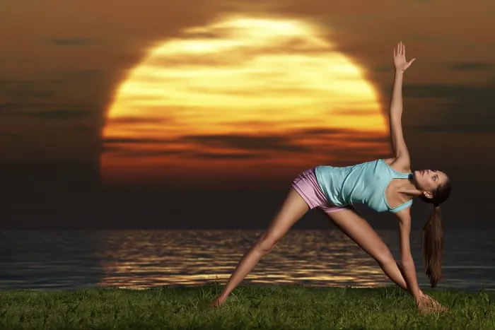 Framed Print : An athletic, beautiful woman practising yoga on the beach at dawn