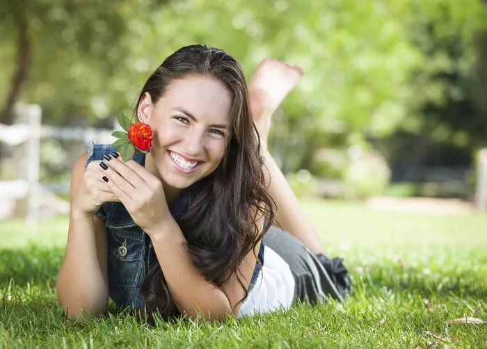 Framed Print : Attractive mixed-race girl portrait laying in grass outdoors with flower