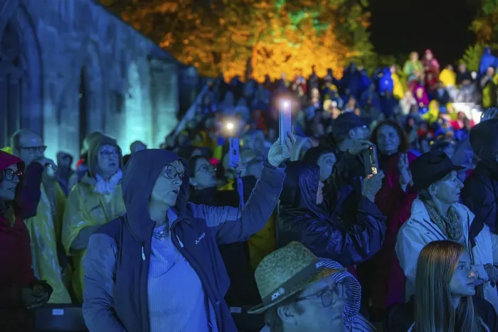 Framed Print : Audience using mobile phones at a night-time event in rainwear Framed Print : Audience using mobile phones at a night-time event in rainwear