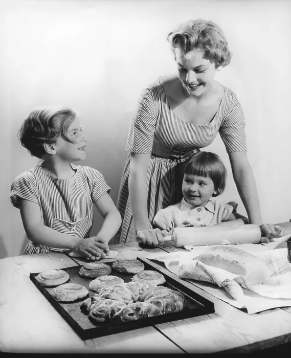 Framed Print : Baking in the 1950s. A mother with her children baking buns and bread together at a table Framed Print : Baking in the 1950s. A mother with her children baking buns and bread together at a table
