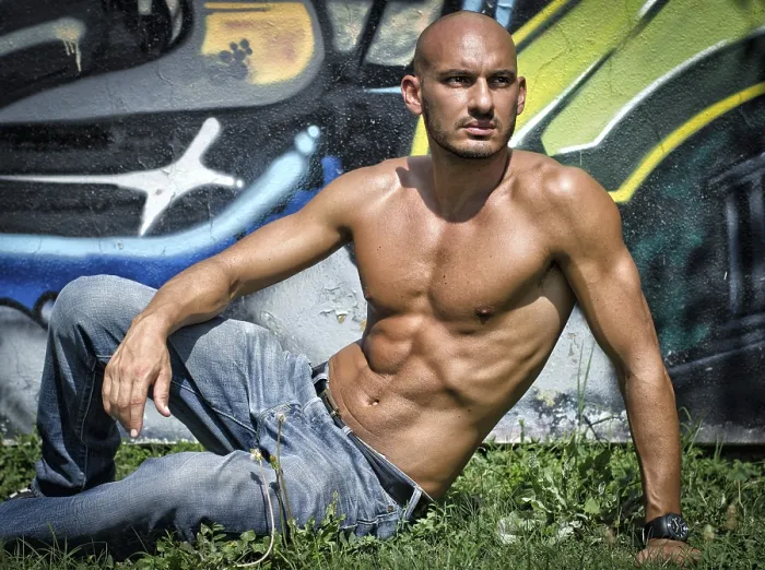 Framed Print : Bald young man shirtless outdoors sitting in front of graffiti wall on grass Framed Print : Bald young man shirtless outdoors sitting in front of graffiti wall on grass
