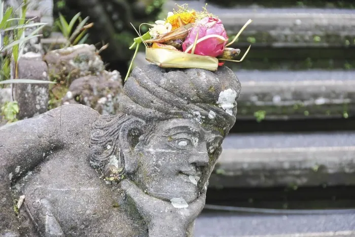 Framed Print : Balinese religious offering (canang sari) over a stone statue Framed Print : Balinese religious offering (canang sari) over a stone statue