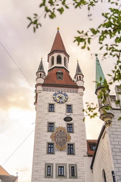 Framed Print : Baroque tower with red roofs and clock in front of a gold-coloured sky Framed Print : Baroque tower with red roofs and clock in front of a gold-coloured sky
