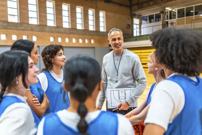 Framed Print : Basketball coach holding clipboard and explaining game strategy to a group of female athletes in a gymnasium Framed Print : Basketball coach holding clipboard and explaining game strategy to a group of female athletes in a gymnasium