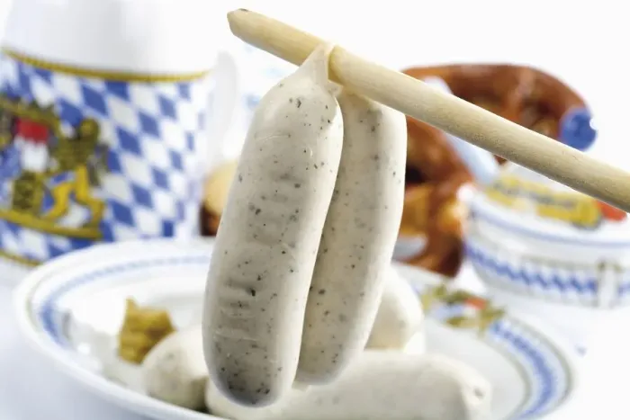 Framed Print : Bavarian veal sausages hanging from a spoon handle