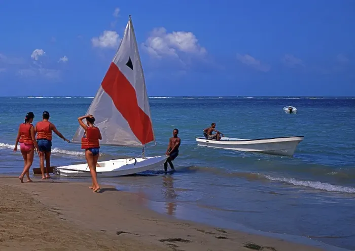 Framed Print : Beach, helper pulls sailboat into the water for 3 tourists, Playa Dorada, Dominican Republic, Central America