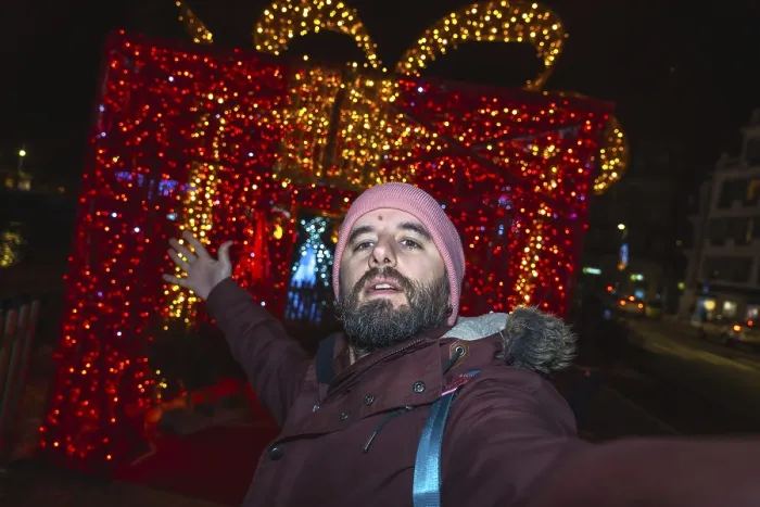 Framed Print : Bearded man taking a selfie in front of giant luminous christmas gift box in bayonne