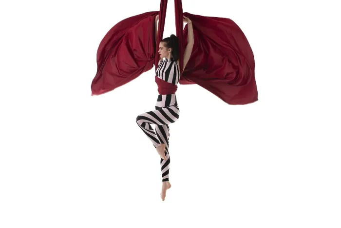 Framed Print : Beautiful charming slim gymnast with upped hands hanging on red material on white background
