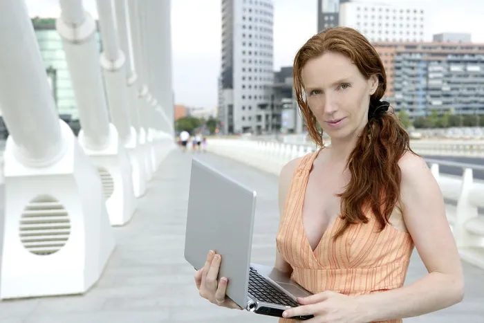 Framed Print : Beautiful redhead woman in downtown bridge with laptop