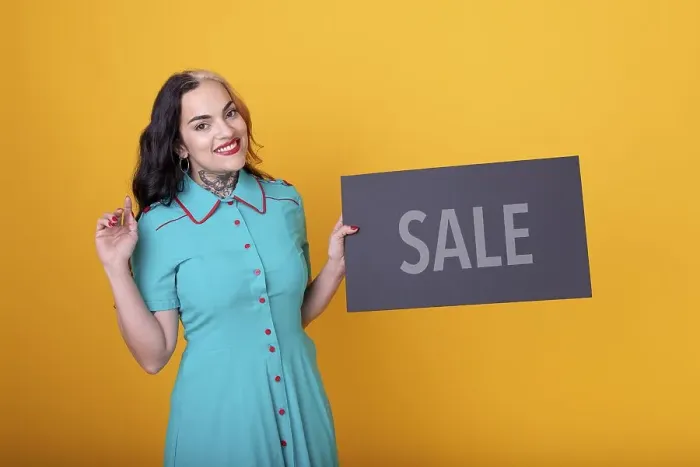Framed Print : Beautiful woman holding a Sale sign