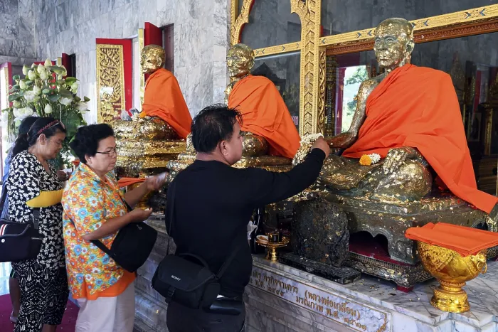 Framed Print : Believers cover statues of monks with gold leaf