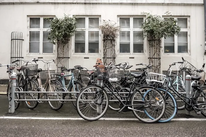 Framed Print : Bicycles lined up against a building facade with white windows on an urban street
