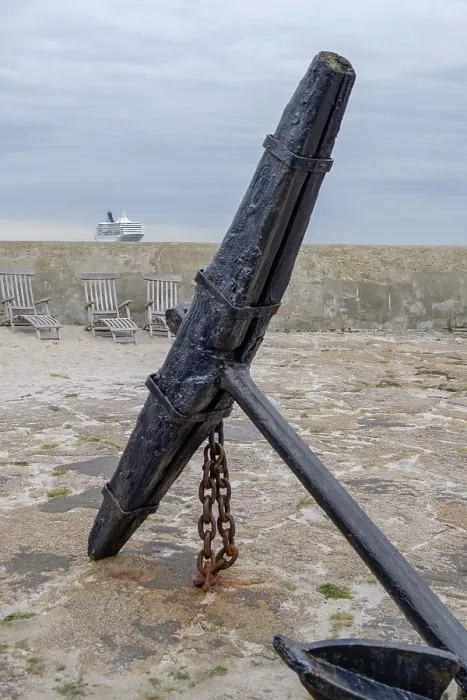 Framed Print : Big old anchor on a rocky coast with a cruise ship on the horizon