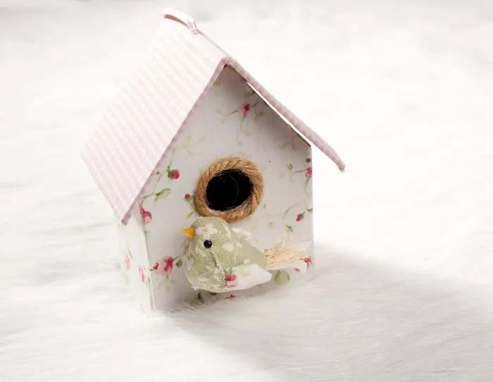 Framed Print : Bird in a nest fabric house with round window in pastel colors