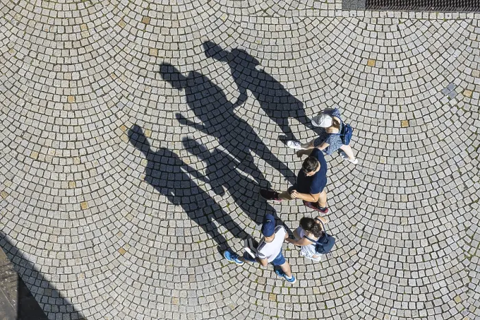 Framed Print : Birds eye view of four people, a family walking across a square with cobblestones Framed Print : Birds eye view of four people, a family walking across a square with cobblestones
