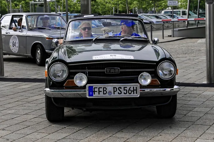 Framed Print : Black cabriolet classic car with two people in front view during a car event