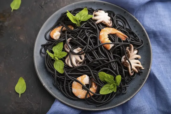 Framed Print : Black cuttlefish ink pasta with shrimps or prawns and small octopuses on black concrete background and blue textile Framed Print : Black cuttlefish ink pasta with shrimps or prawns and small octopuses on black concrete background and blue textile
