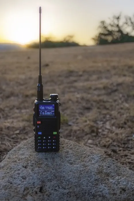 Framed Print : Black handheld transceiver standing on a rock in a field at sunset Framed Print : Black handheld transceiver standing on a rock in a field at sunset