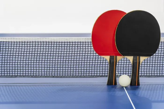 Framed Print : Black and red table tennis racket and a white ball on the blue ping pong table with a net