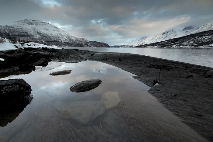 Framed Print : Black rocky coast in a bay in the Ullsfjord