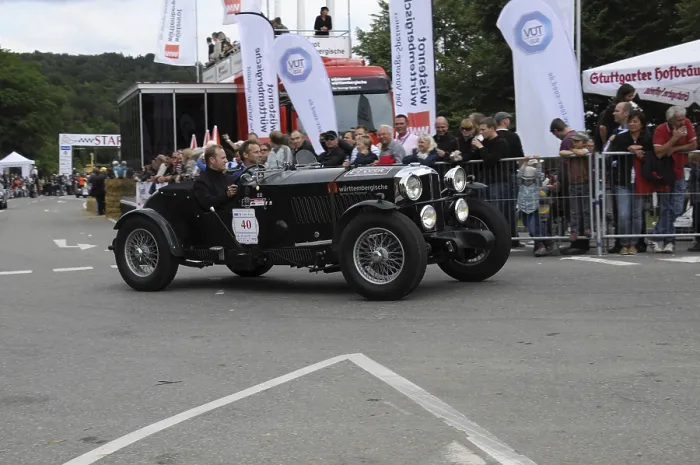 Framed Print : A black vintage car drives past spectators at a racing event
