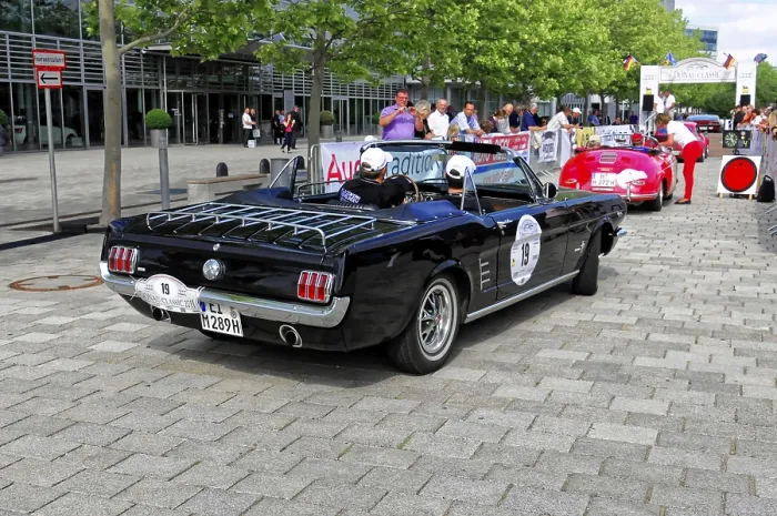 Framed Print : Black vintage convertible with racing stickers at a car event on a paved road