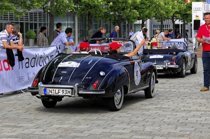 Framed Print : Two black vintage convertibles on a street surrounded by a crowd