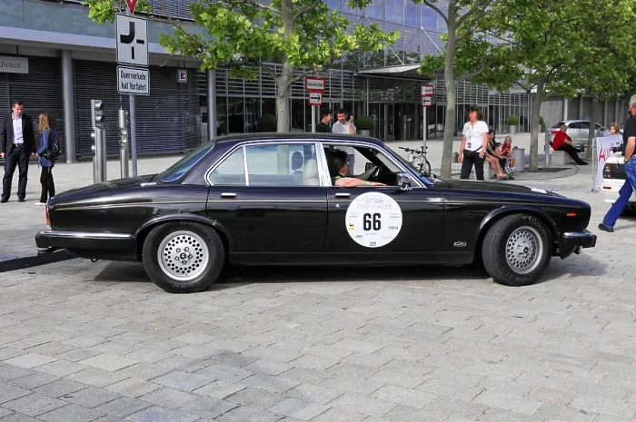 Framed Print : Black vintage limousine with number 66 in an urban setting with trees and people