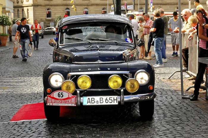 Framed Print : A black Volvo classic car with yellow headlights on a paved road