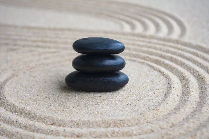 Framed Print : Black zen stones inside lines carved on sand with customizable space for text Framed Print : Black zen stones inside lines carved on sand with customizable space for text