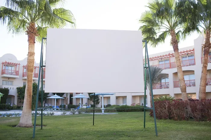 Framed Print : Blank billboard with tropical palm trees standing on a green lawn in front of an apartment block or resort
