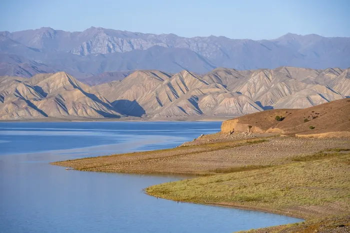 Framed Print : Blue Toktogul reservoir between dry mountain landscape