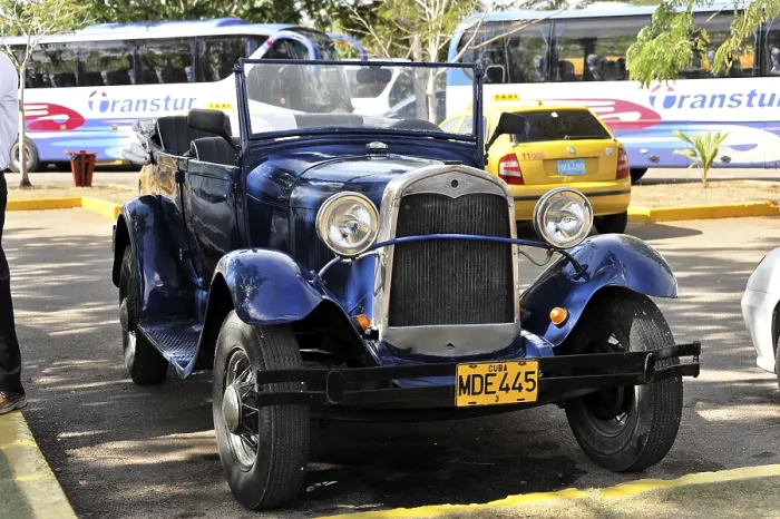 Framed Print : A blue vintage car parked under the sun with its licence plate visible