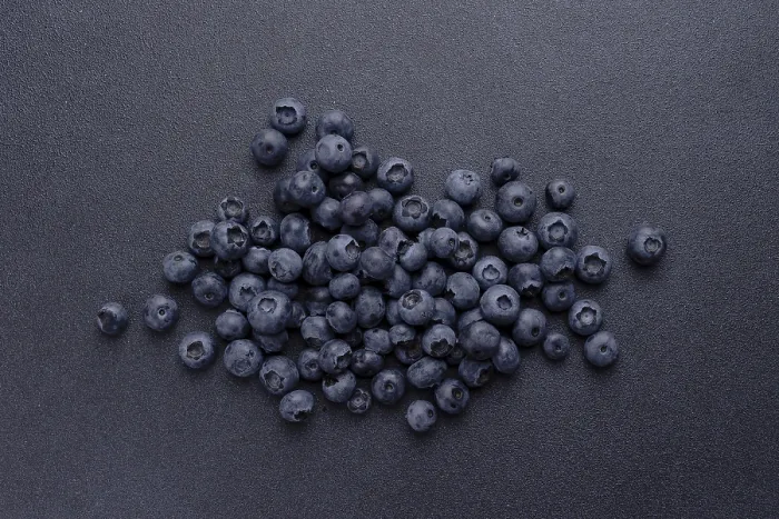 Framed Print : Blueberries are scattered on a blue background