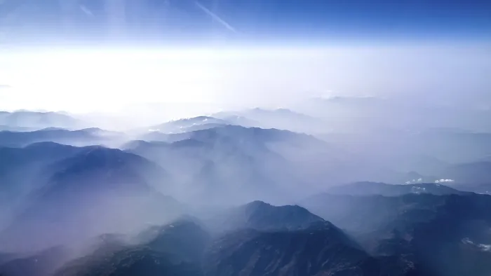Framed Print : Blurred mountain ranges covered with fog and clouds in the distance